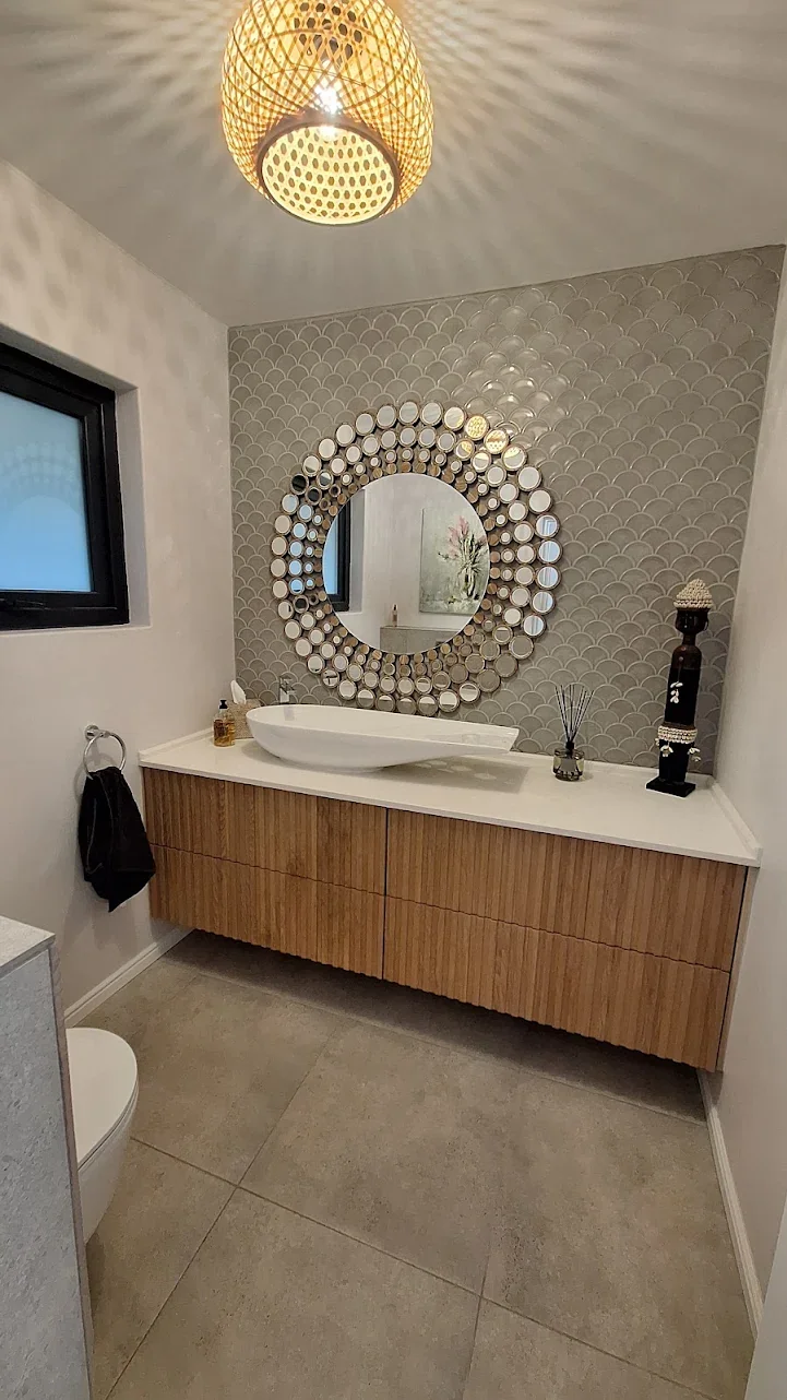 Decorative bathroom feature wall tiling with round mirror design