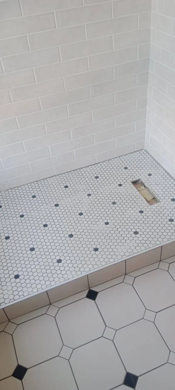 Bathroom wall tiling with white brick tiles and mosaic tiled bench surface