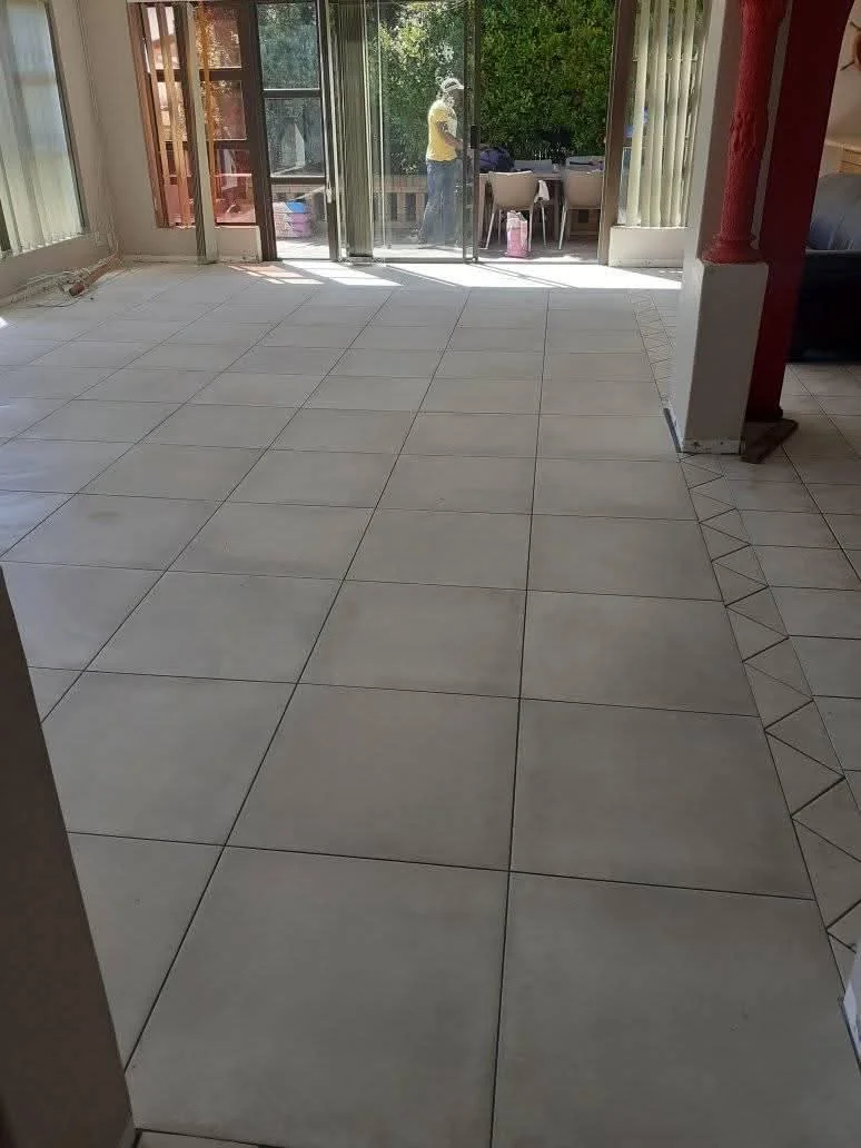 Open-plan floor tiling installation with level transitions across connected rooms