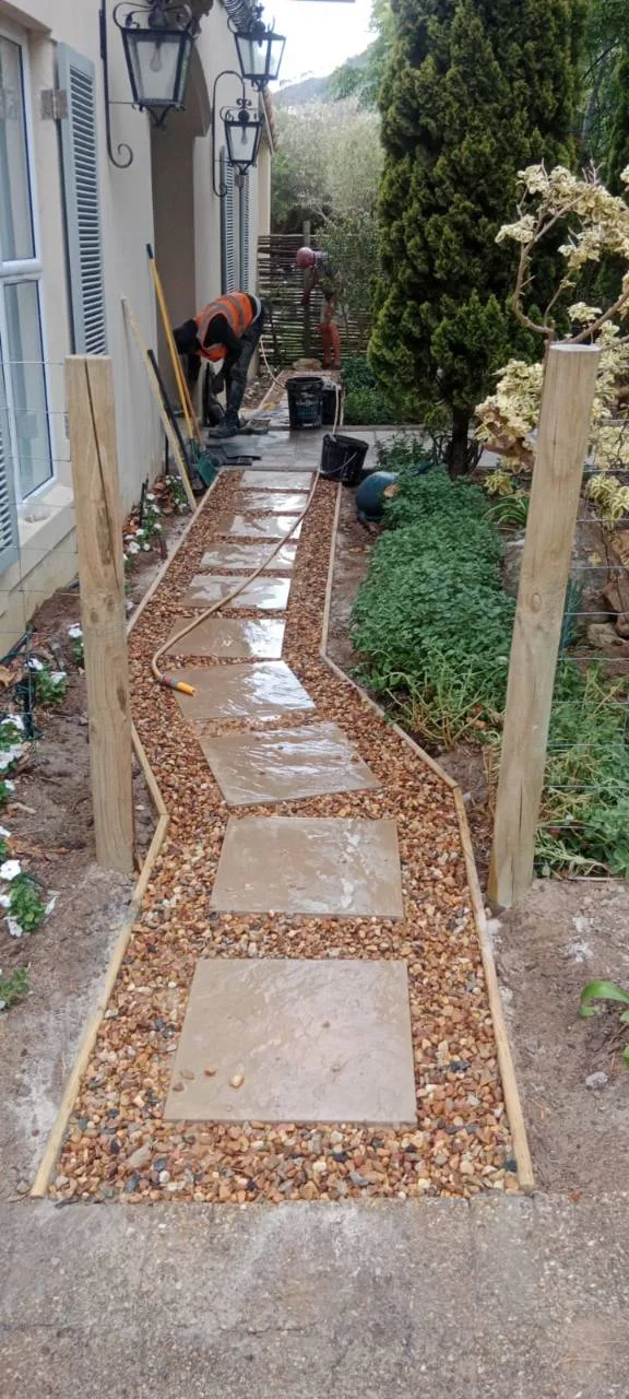 Outdoor pathway tiling with large pavers set into a garden walkway