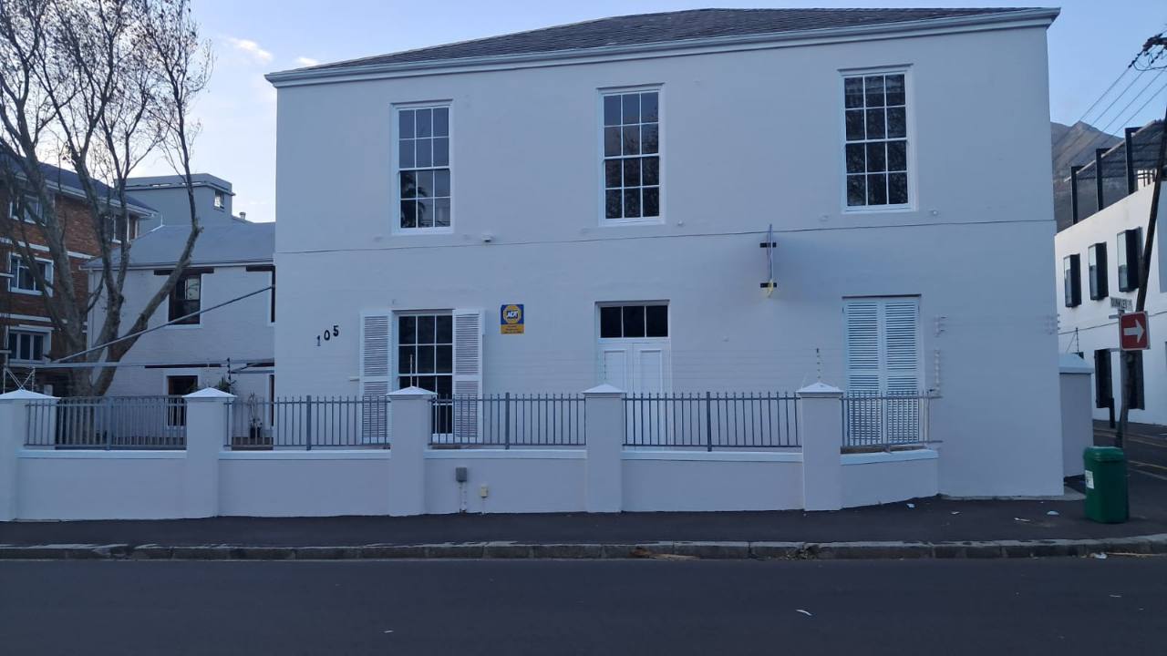 Exterior building painted white with clean wall and window finishes