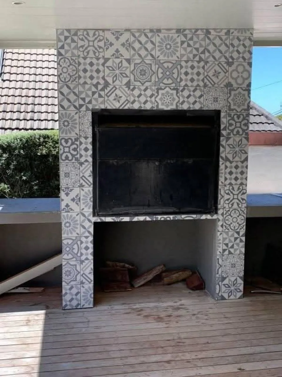 Covered patio braai area finished with patterned grey wall tiles around the built-in braai